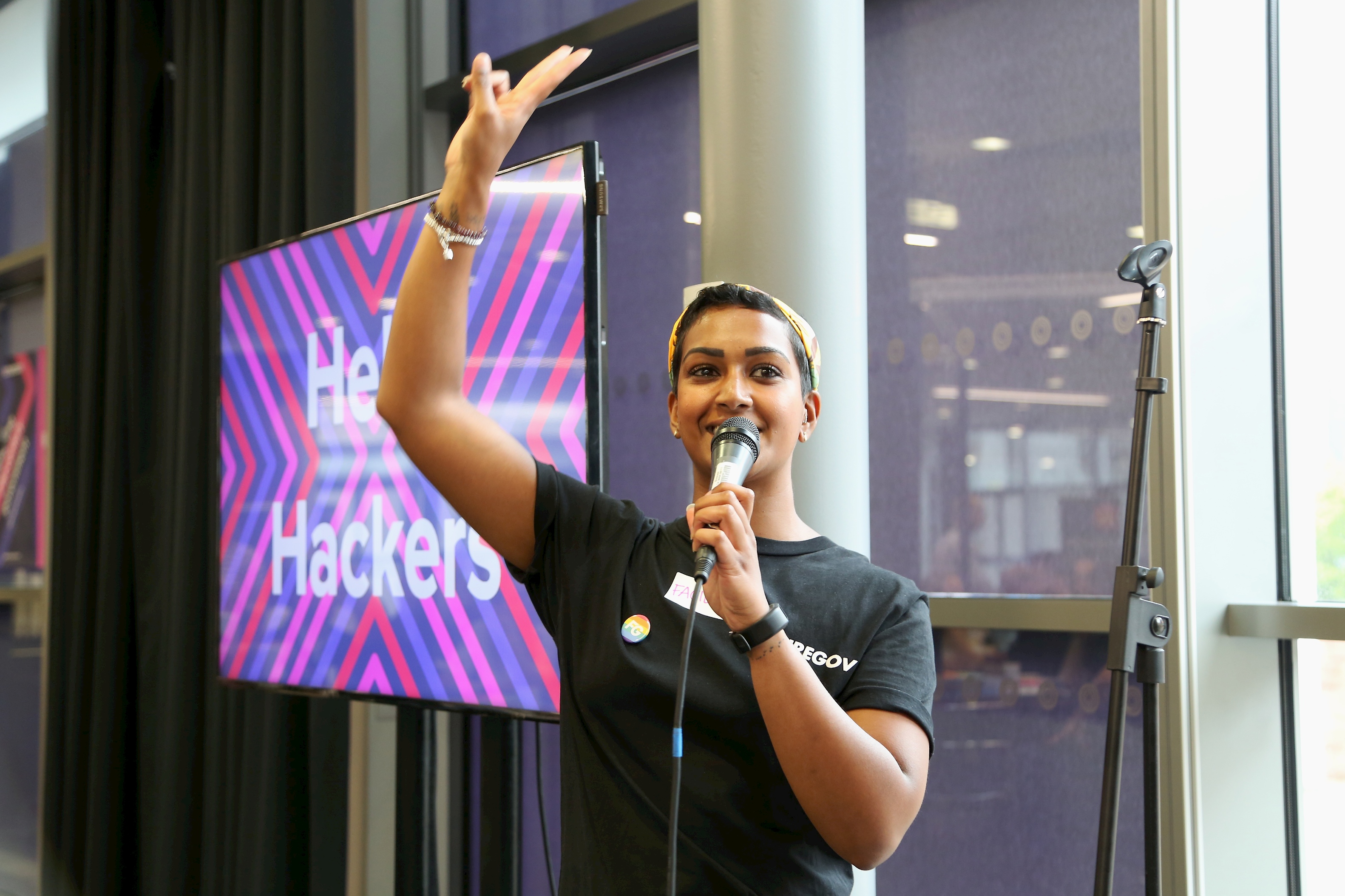 Vimla Appadoo speaking into a microphone at an event, arm raised mid-gesture